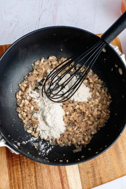 Whisking flour into the mushroom, garlic, and shallot mix for the green bean casserole