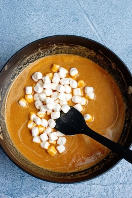 Adding marshmallows to peanut butter fudge mix