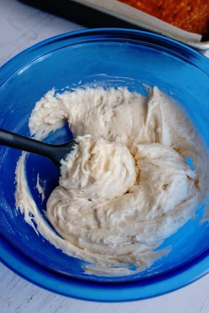 Mixing together the brown butter frosting in a bowl