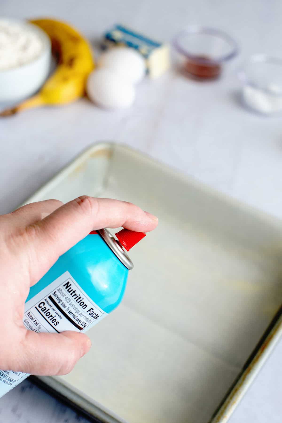 Spraying a baking pan with non-stick cooking spray