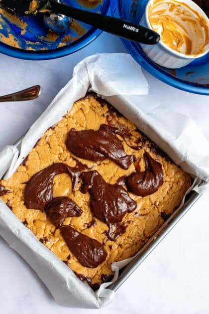 Adding the remaining chocolate mixture to the peanut butter layer