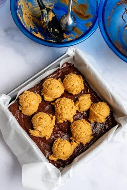 Adding dollops of peanut butter mixture on top of the chocolate mixture