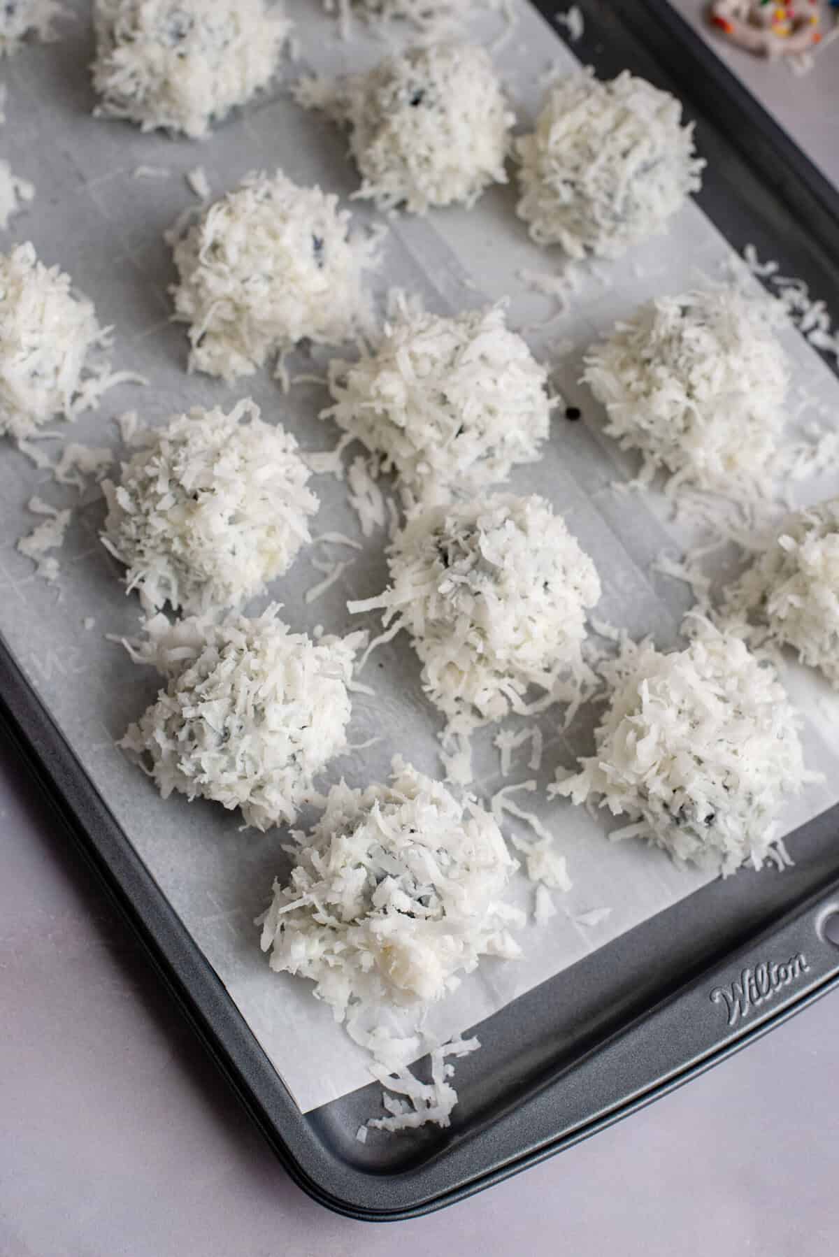 Coconut-coated Oreo balls on a baking sheet ready to cool
