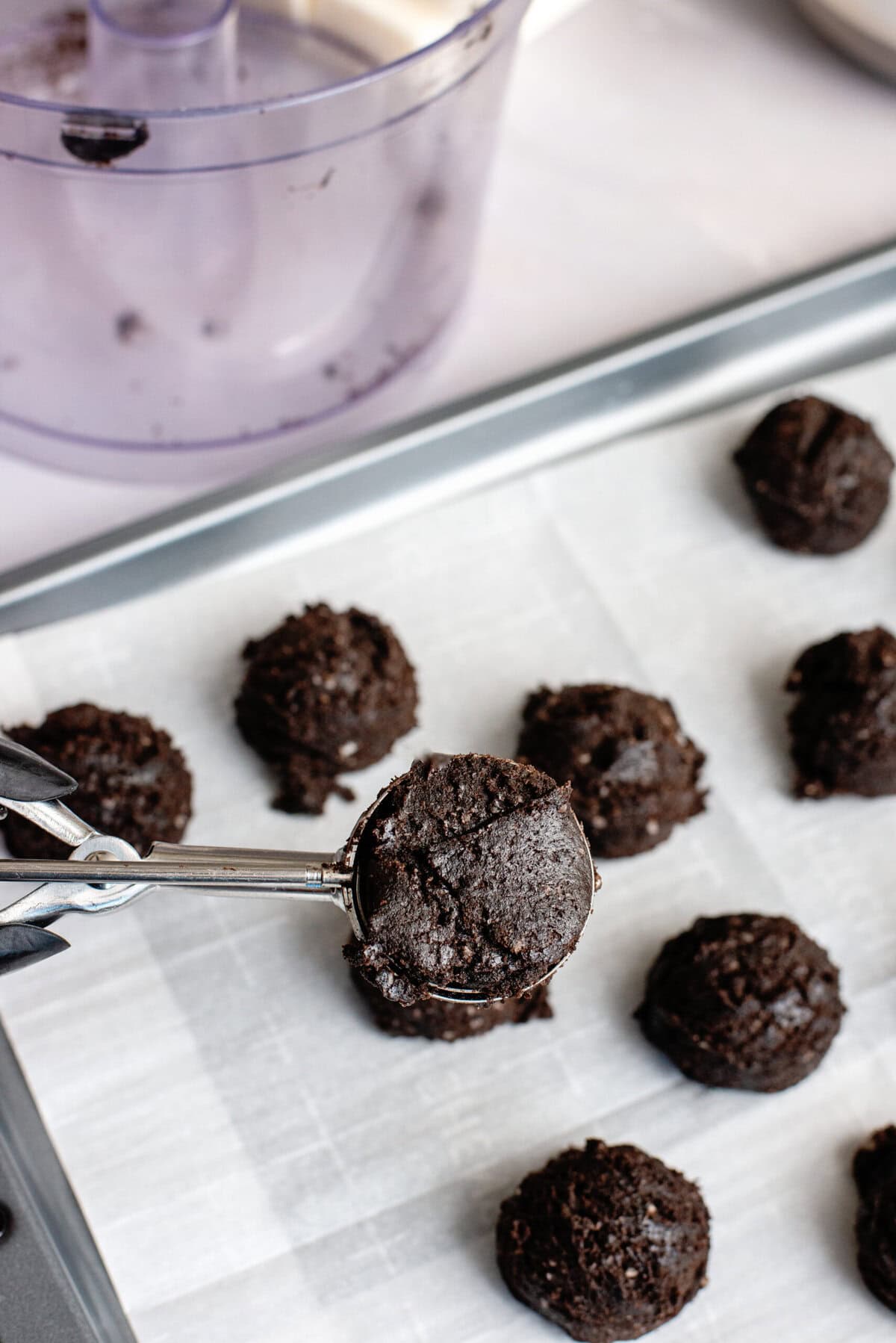 Scooping Oreo balls onto a baking sheet