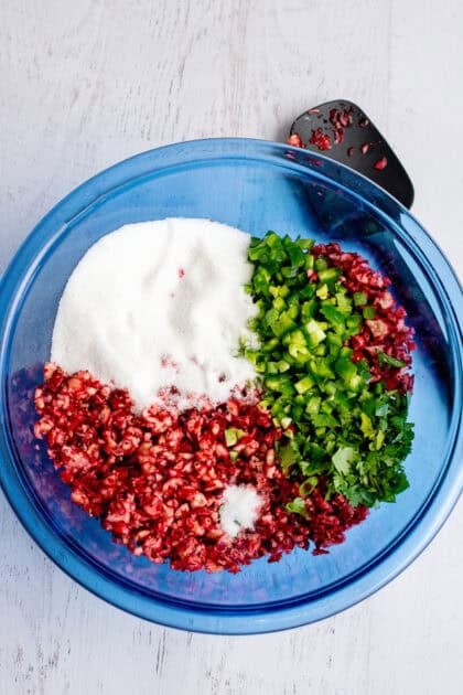 Cranberries, jalapeños, chopped cilantro, green onions, sugar, lime juice, and salt in a bowl