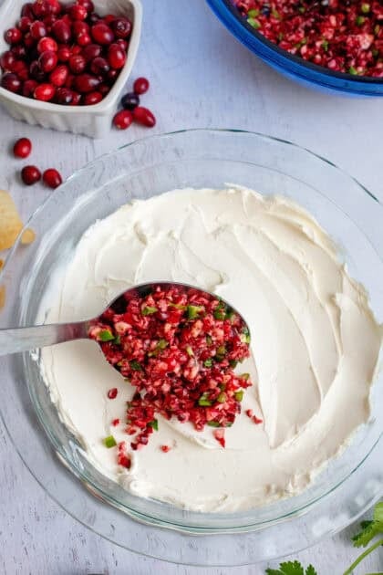 Pouring the cranberry and jalapeño mix on top of the cream cheese base