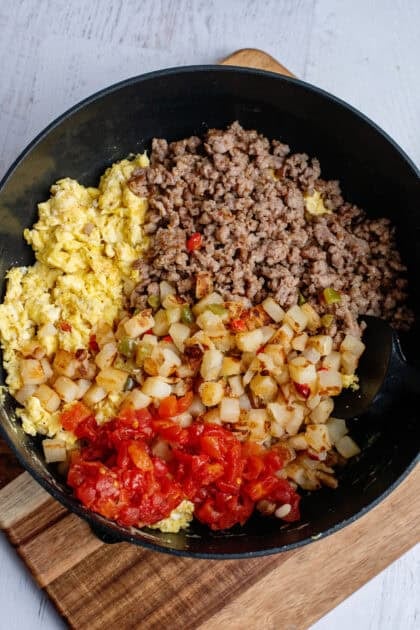 A skillet with the cooked breakfast burrito filling