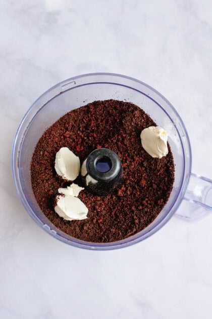 Cream cheese in a food processor with Oreo crumble