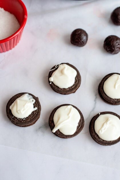 Oreo cookie balls on top of Oreo cookies