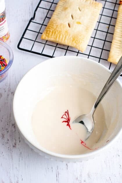 A bowl of glaze for the homemade strawberry pop-tarts