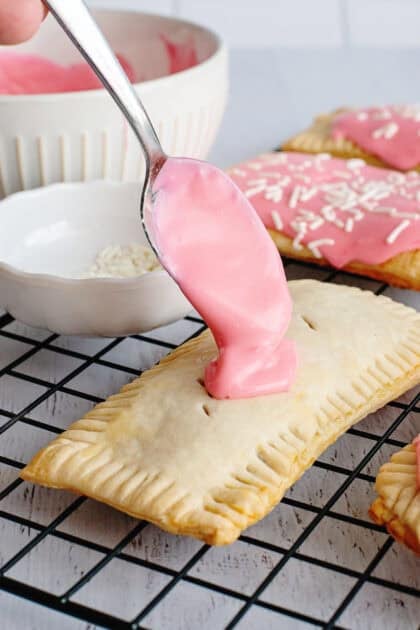 Spreading the strawberry glaze on homemade strawberry pop-tarts