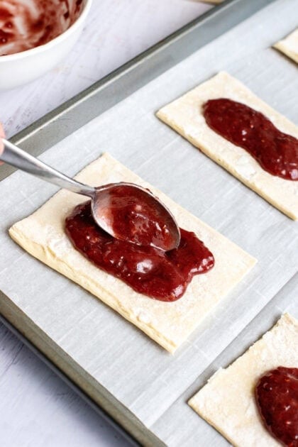 Filling the pastry squares with jam filling