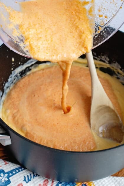 Adding the blended veggie sauce to a pan