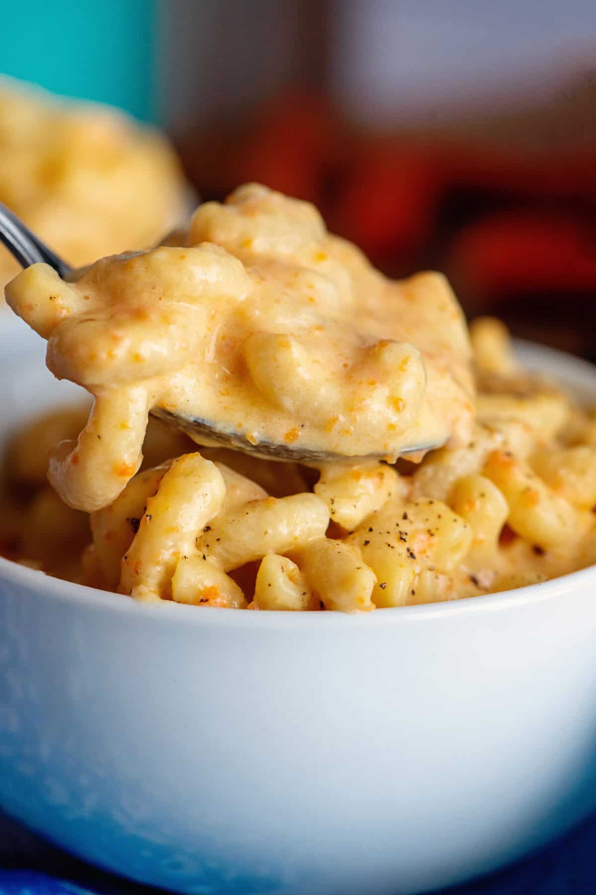 Taking a spoonful of mac and cheese with hidden veggies from a bowl
