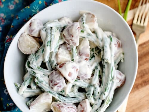 A bowl of creamed beans and Taters on a cutting board