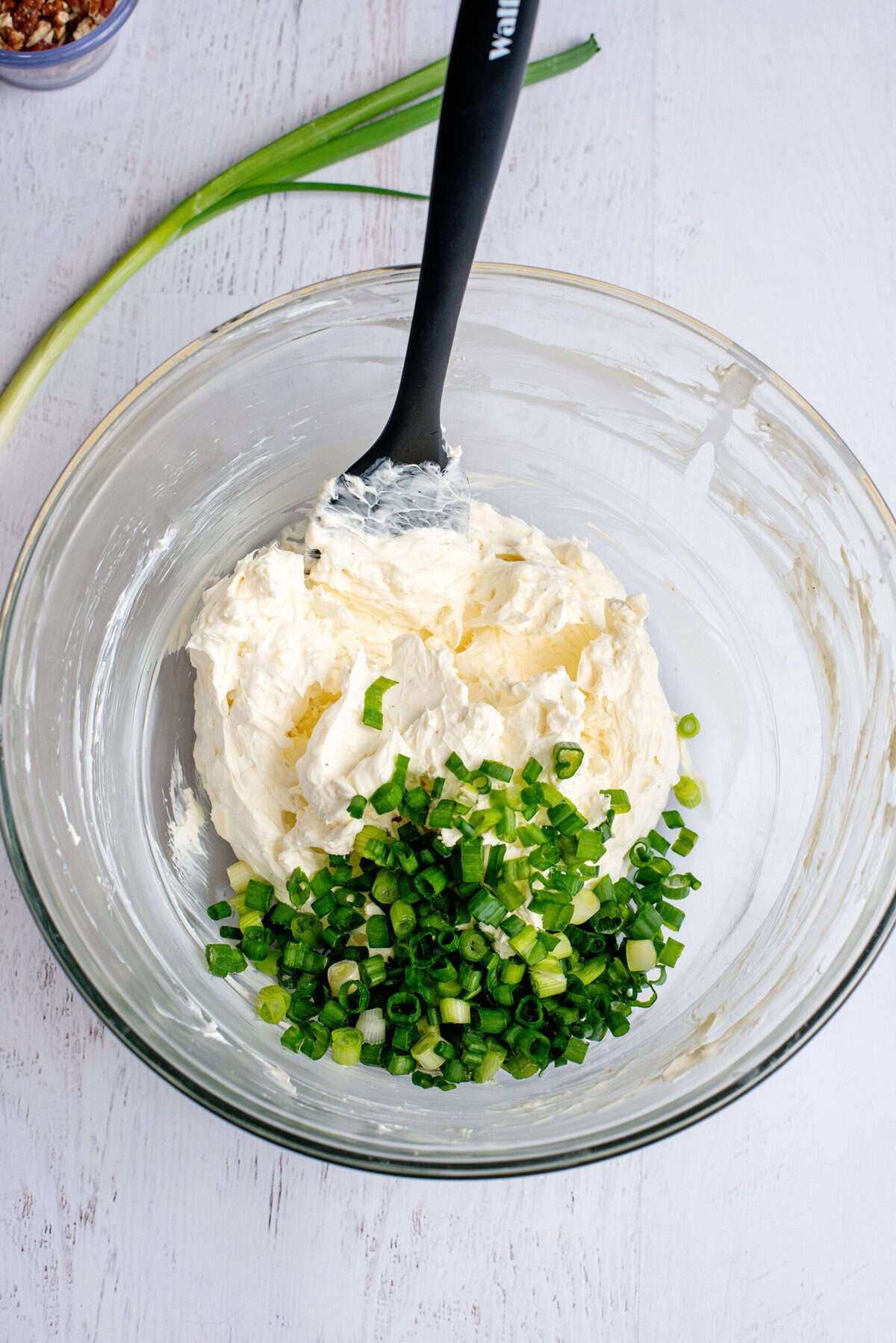 Adding green onion to the beaten cream cheese mix