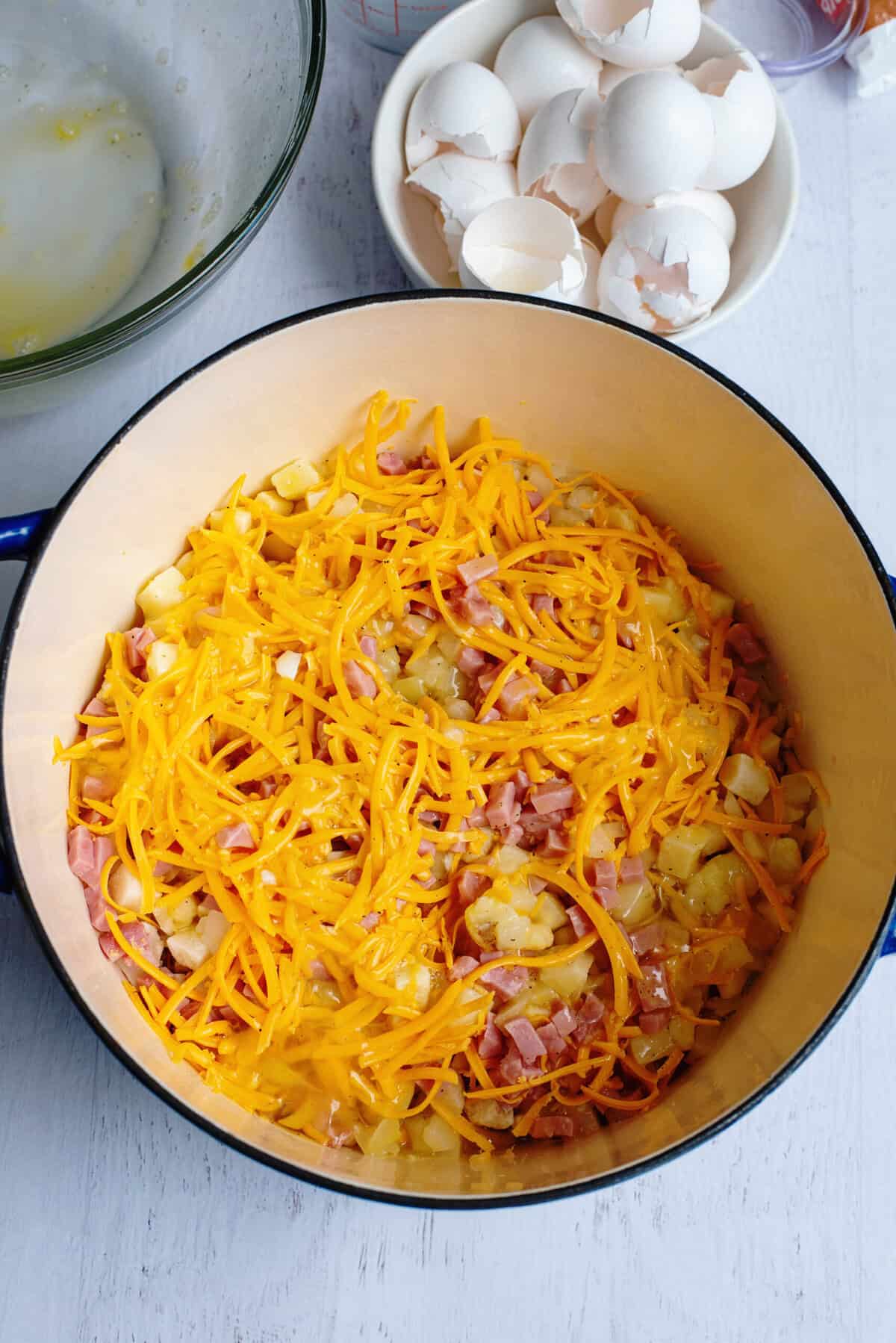 Adding eggs to other ingredients for Ham, Cheese, & Egg Casserole