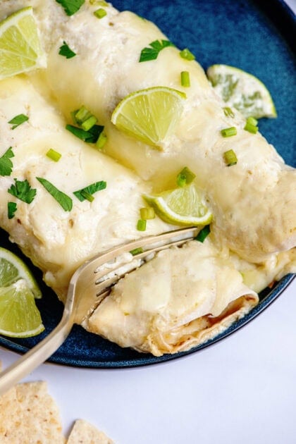 Using a fork to cut the Honey Lime Chicken Enchiladas 