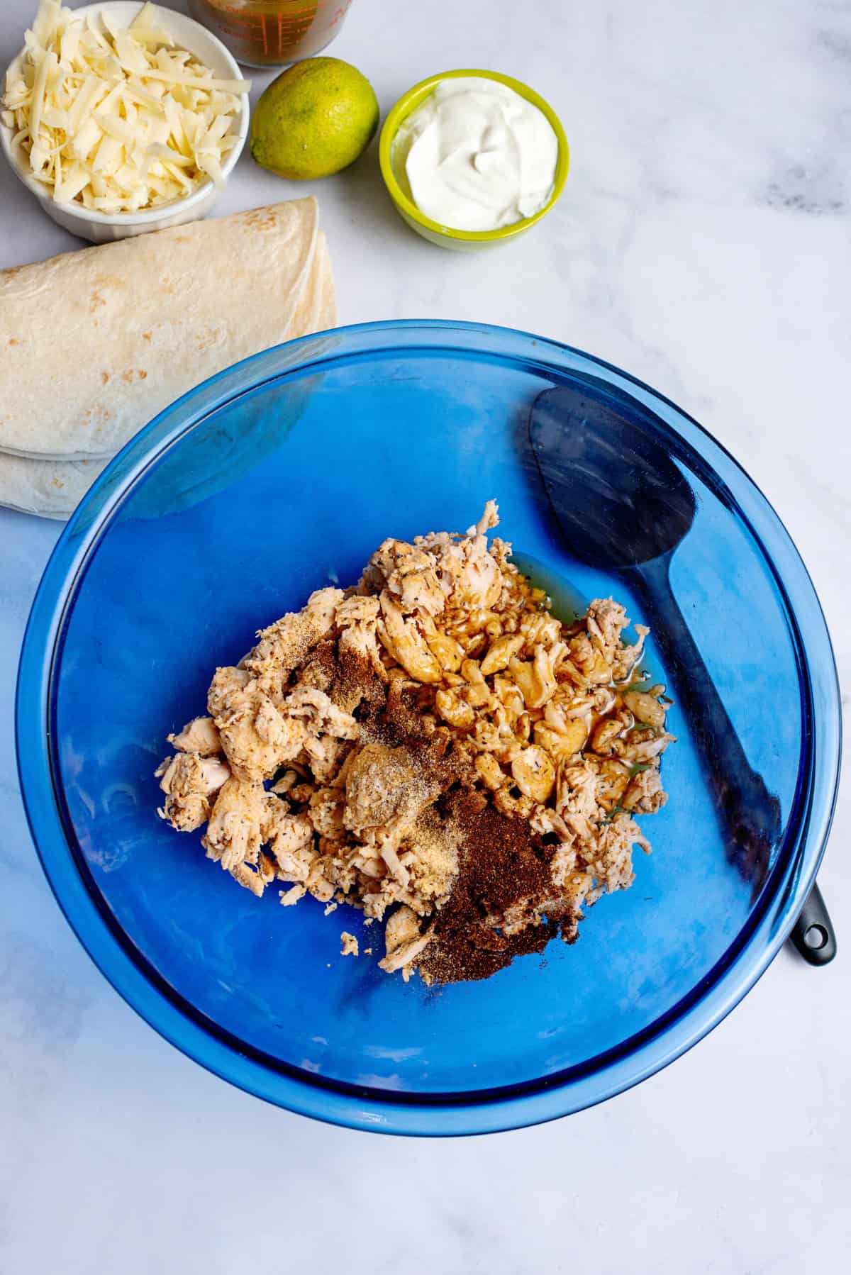 Combining chicken in honey, lime juice, chili powder, cumin, garlic powder, and salt. 