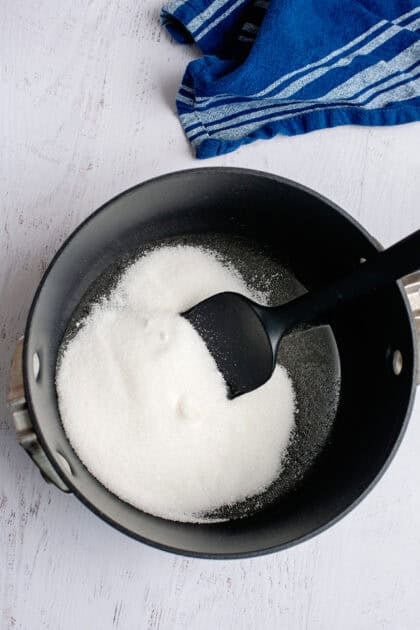 Combining sugar and light corn syrup in a pan