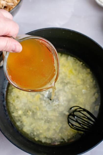 Adding chicken broth to a skillet