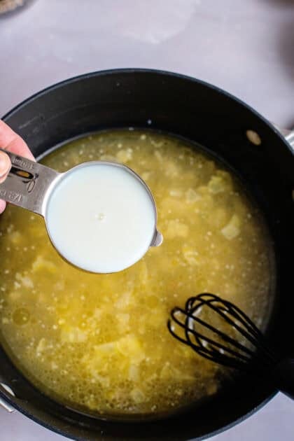 Adding heavy cream to a skillet with chicken stock