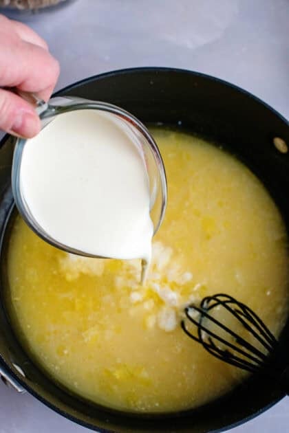Adding milk to a skillet with heavy cream and chicken stock