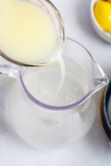 Pouring the lemon juice into a pitcher of water