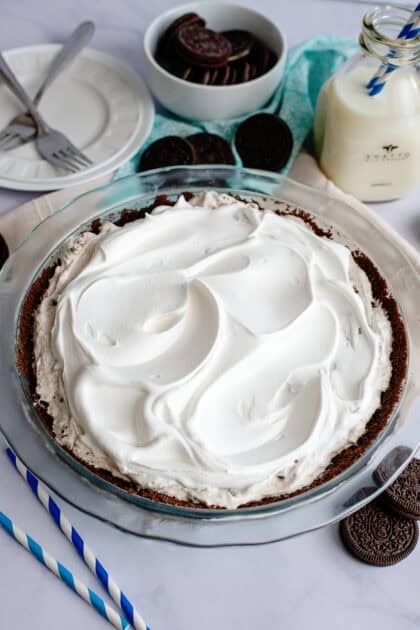 Adding whipped cream to the Oreo cheesecake pie
