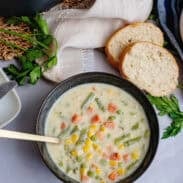 A bowl of low carb vegetable soup next to bread