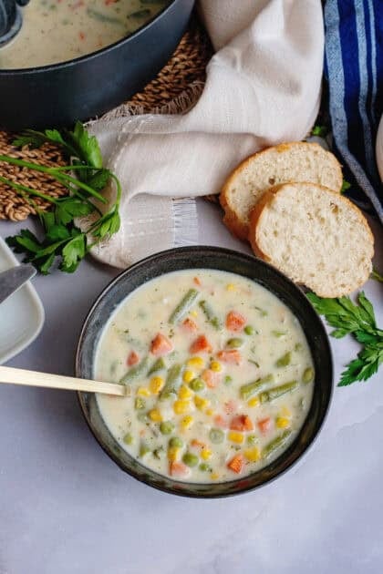A bowl of low carb vegetable soup next to bread