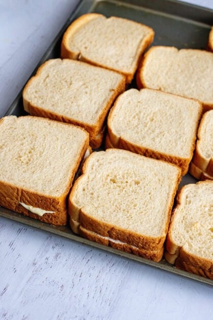 Cream cheese-filled bread sliced on a baking sheet