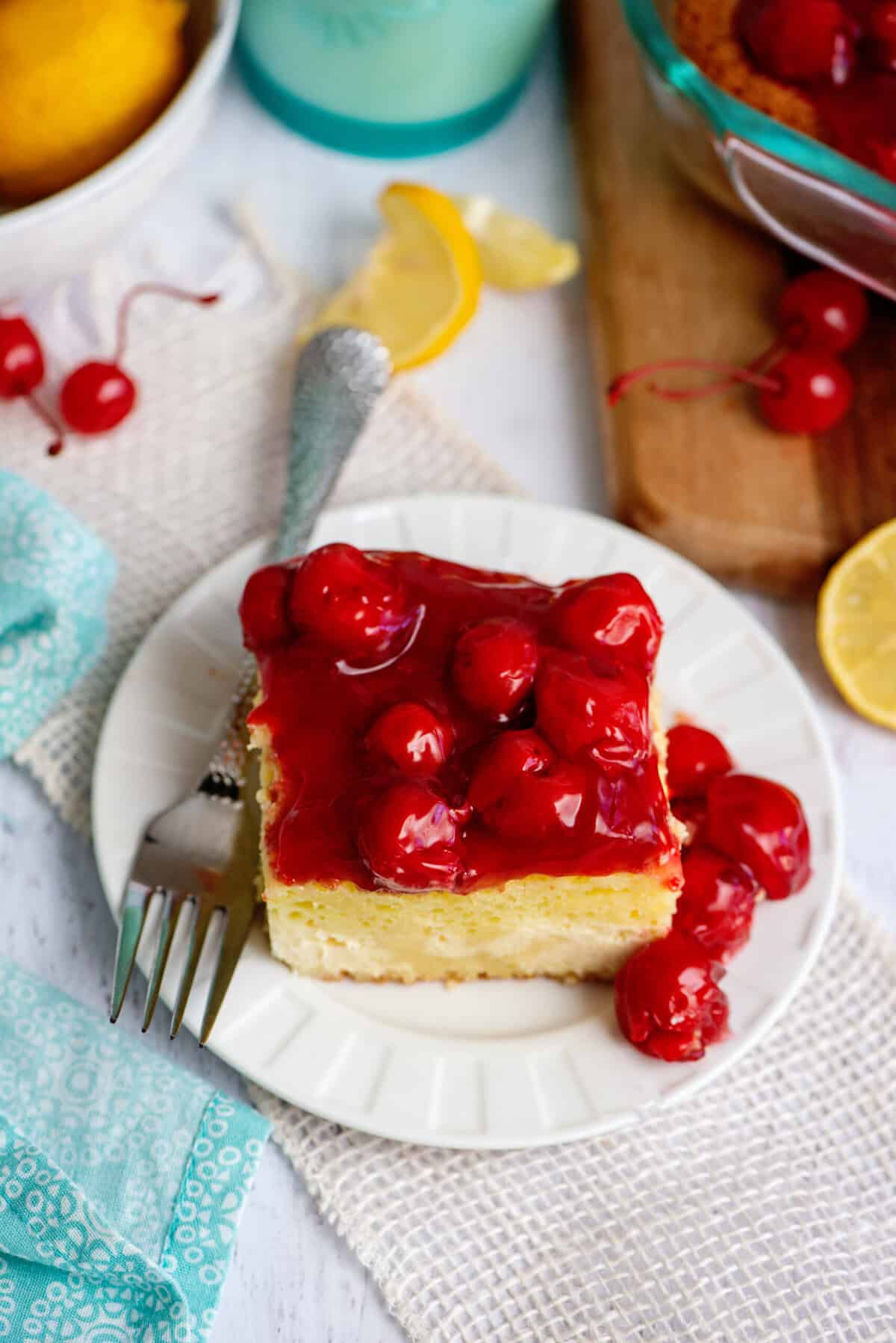A plate with one serving of lemon cherry cheesecake