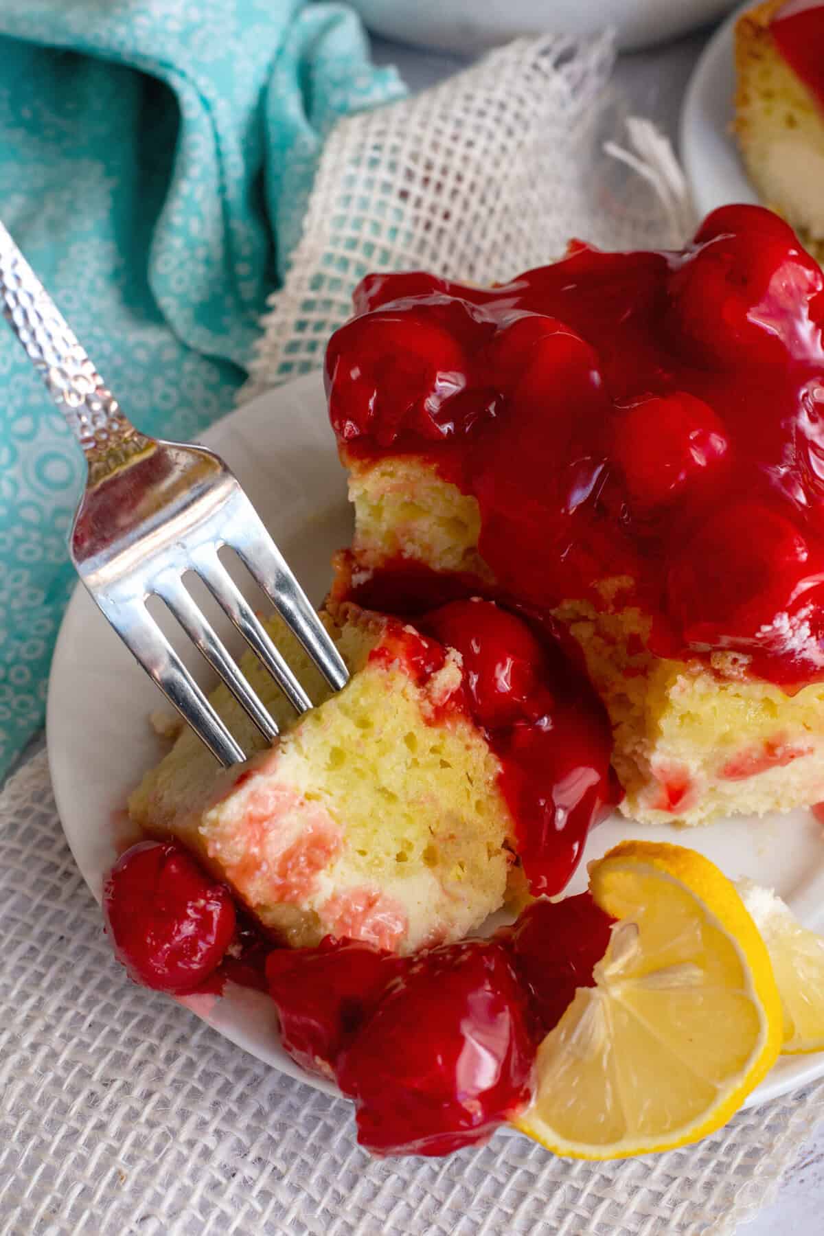 Taking a piece of lemon cherry cheesecake with a fork
