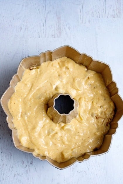 Adding the remaining pear bundt cake batter to the mold