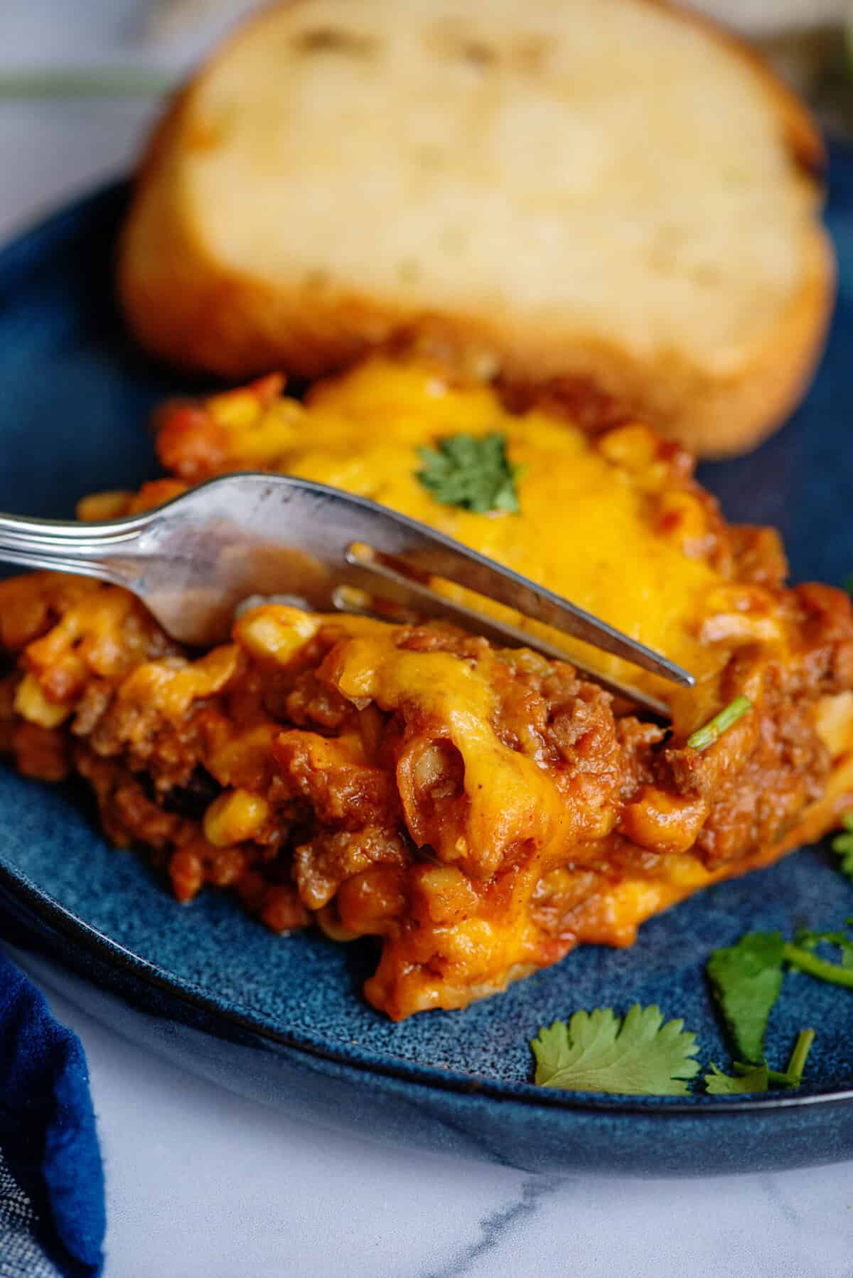 Using a fork to take a bite of a serving of Tex Mex Lasagna