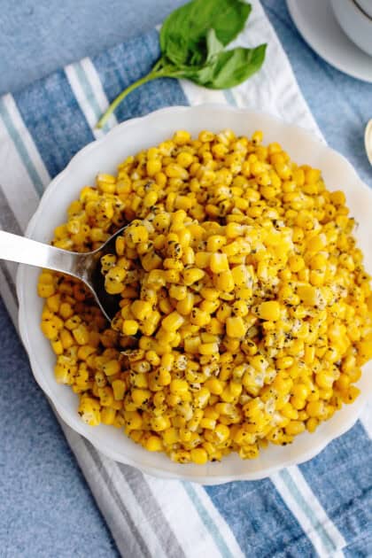 Taking a spoonful of Basil Corn from a plate