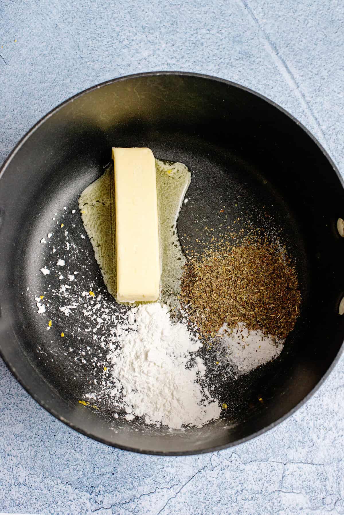 Butter, cornstarch, salt, sugar, and dried basil in a pot.
