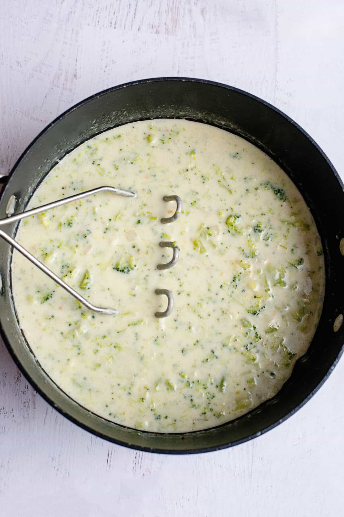Mashing Broccoli Cheese and Bacon Soup
