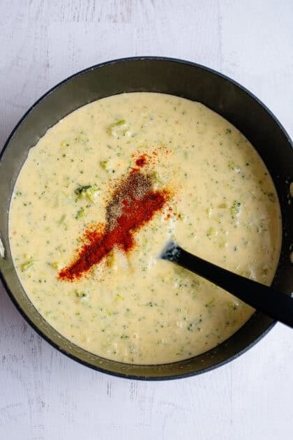 Adding seasoning to Broccoli Cheese and Bacon Soup