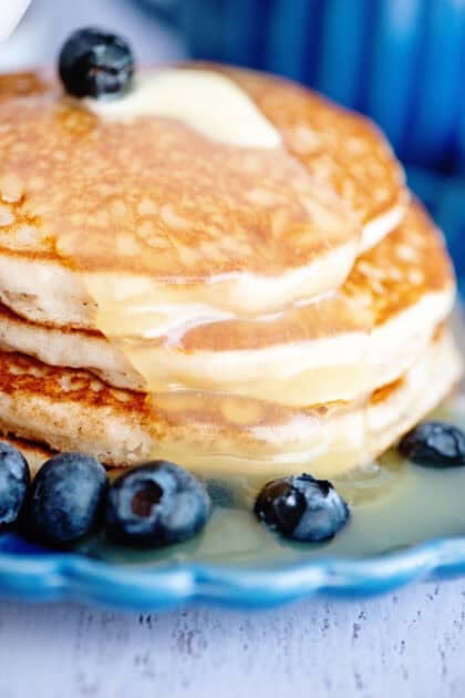 Stack of buttermilk pancakes drenched in homemade buttermilk syrup