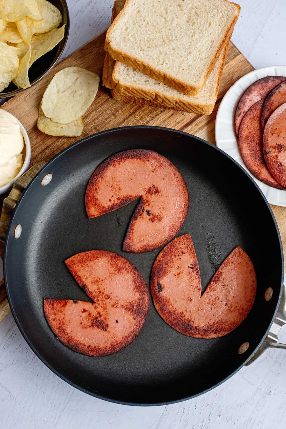 Frying slices of bologna in a pan