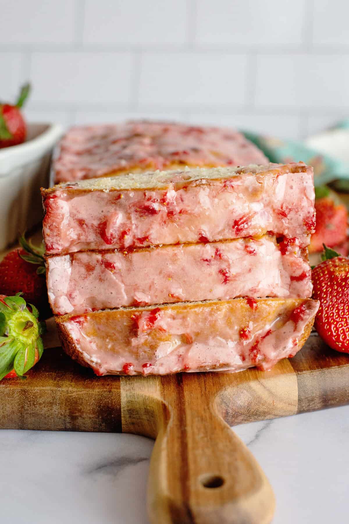 3 slices of strawberry bread with glaze stacked on each other