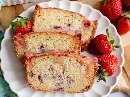 A plate with 3 slices of strawberry bread with glaze