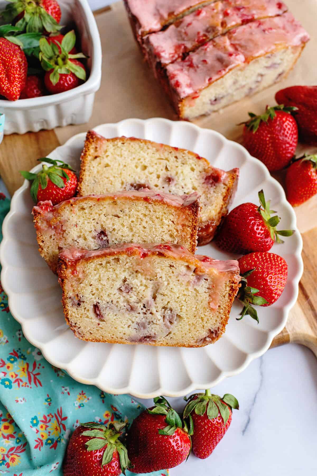 A plate with 3 slices of strawberry bread with glaze