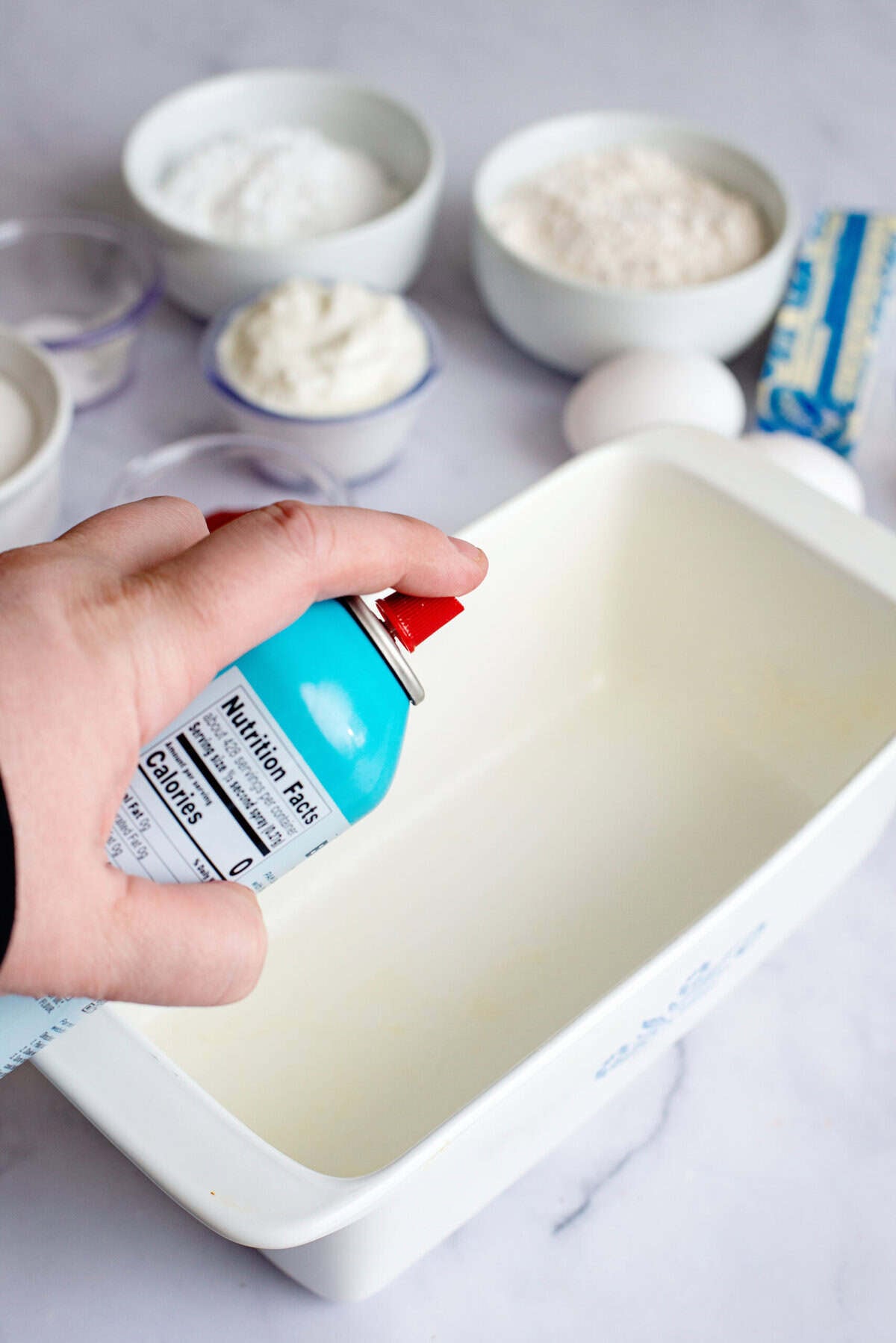 Spraying a pan with non-stick spray