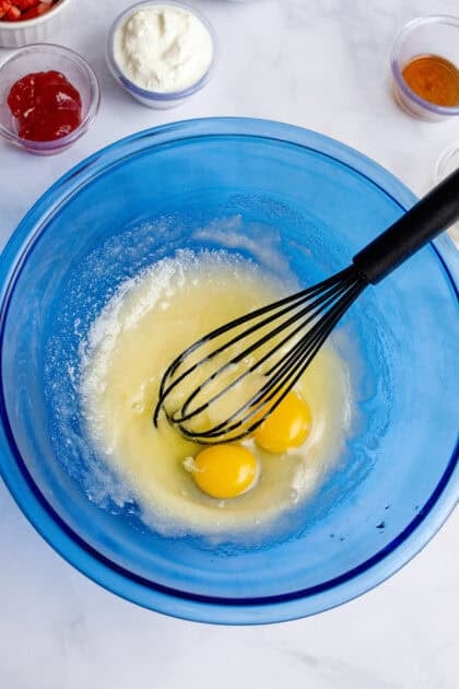 Adding eggs to mixing bowl