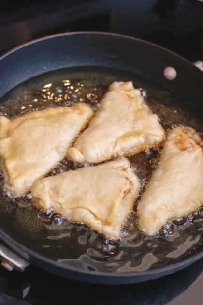 Raspberry and chocolate beignets in a frying pan
