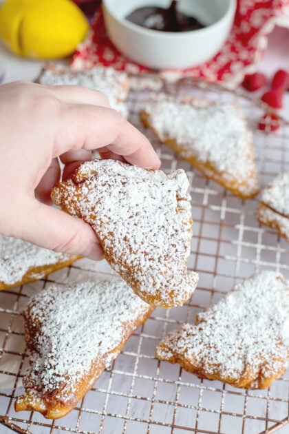 Holding a powdered beignet
