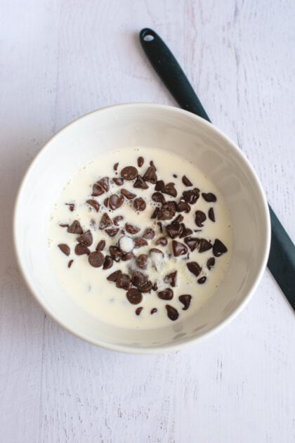 A bowl of chocolate chips and heavy cream